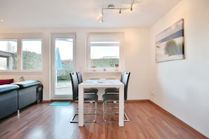 Una cocina moderna con una mesa de comedor, sillas y ventanas amplias.
