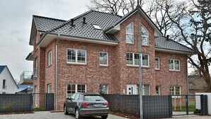 A two-story brick house with a car parked in the driveway. - Baltic Sea Apartment 1 - Baltic Sea (Timmendorfer Strand)