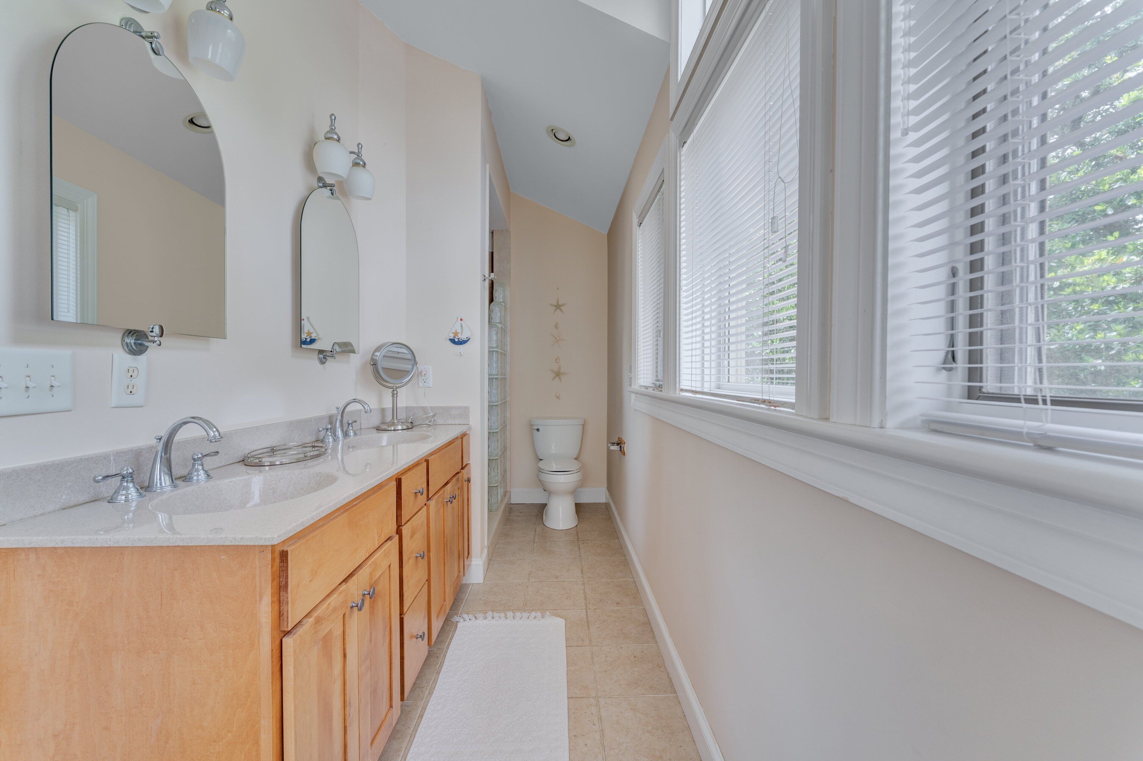 A modern bathroom with a double sink, vanity, and a toilet.