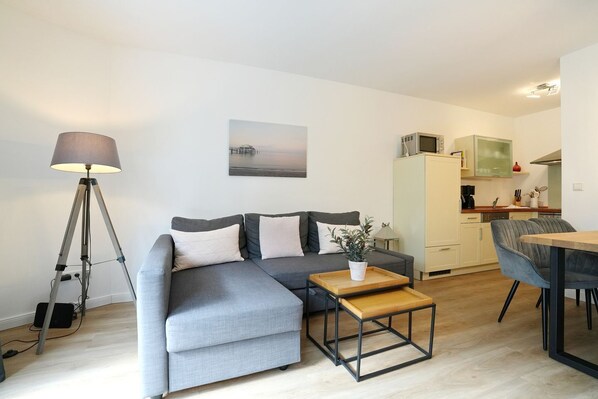 A modern living room with a sofa, coffee table, and lamp.