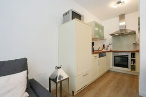 A compact kitchen with a microwave, oven, and a small countertop.
