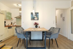 A modern kitchen with white cabinets, a wooden countertop, and a built-in oven.