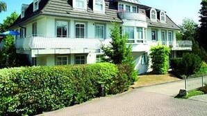 Ein großes, zweistöckiges Gebäude mit einer symmetrischen Fassade, zahlreichen Fenstern und einem zentralen Eingang.