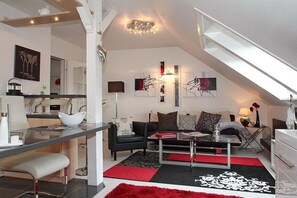 A modern loft apartment with a kitchen, dining area, and living room.