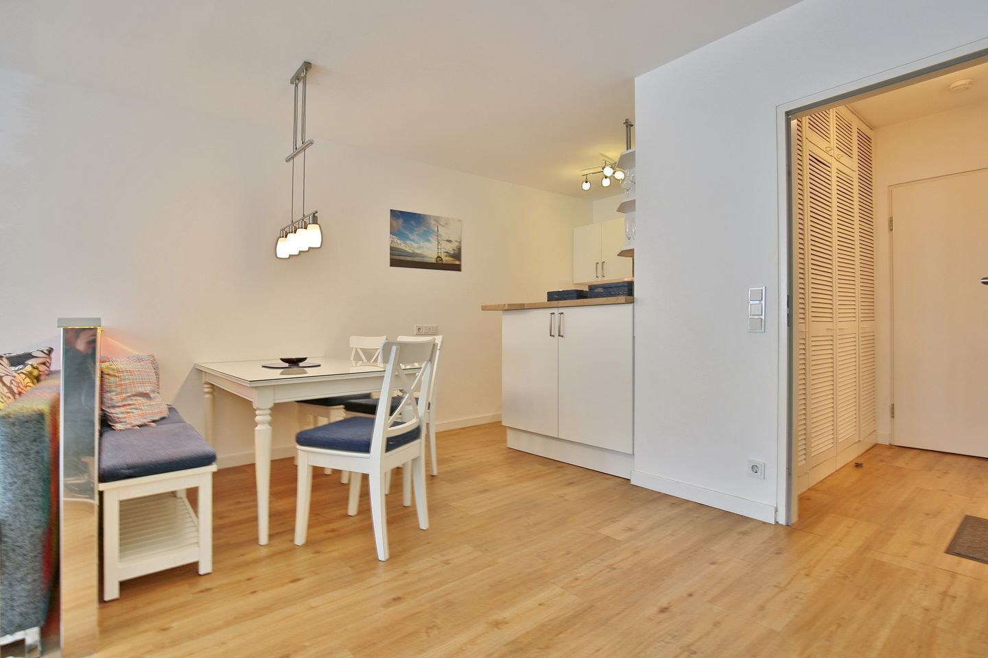 Een knus woongedeelte met een eethoek, een kitchenette en een kledingkast.
