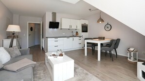 Eine moderne Wohnung mit Küche, Essbereich und Wohnzimmer.