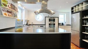 A modern kitchen with a central island, stainless steel appliances, and a built-in wine rack.