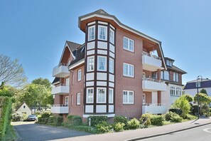 Een meerlaags woongebouw met een hoekligging, met balkons en een bakstenen gevel.