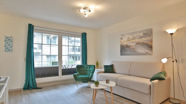 A living room with a sofa, a chair, a coffee table, and a floor lamp.