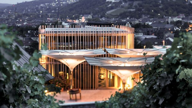 Un bâtiment moderne au design géométrique original, entouré de verdure.