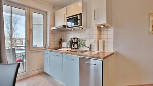 A modern kitchen with a large window, a microwave, and a coffee maker.