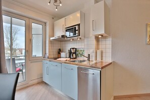 Una cocina moderna con un amplio ventanal, microondas y cafetera.