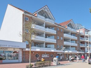 Ein mehrstöckiges Hotel mit Balkonen, einer Ziegel-Fassade und einem Schaufenster mit dem Schild 'point of brands'.