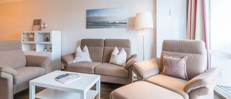Ein modernes Wohnzimmer mit einer Sofagarnitur, einem Couchtisch und einer Lampe.