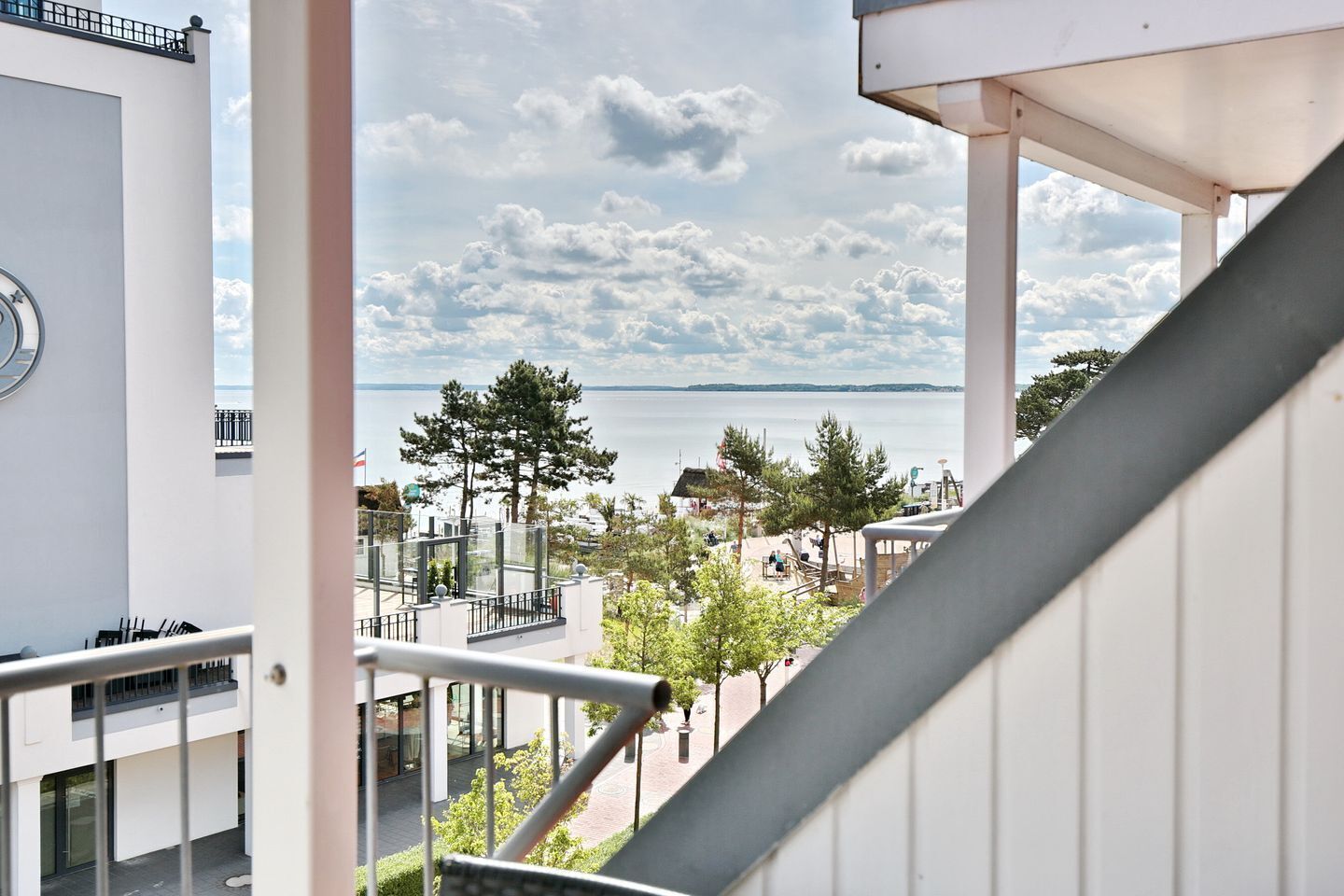 A balcony with a view of a beach and the sea.
