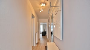 A narrow hallway with wooden flooring, a white radiator, and a ceiling light fixture. - Seebrücke Appartement 2 - Seebrücke (Scharbeutz)