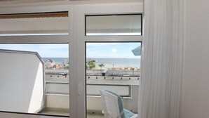 A balcony with a view of the sea and a small boat docked nearby. - Strandperle Apartment 107 - Strandperle (Scharbeutz)