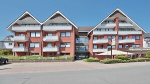 Un immeuble à plusieurs étages doté de balcons, d’un restaurant et d’un espace de stationnement.