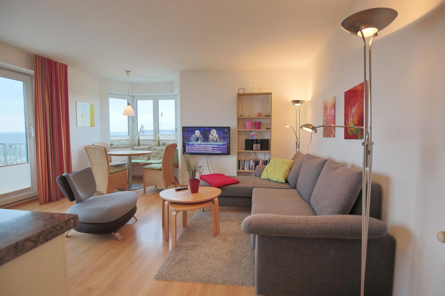 Un salon moderne comprenant un canapé, des fauteuils, un coin repas et un téléviseur.