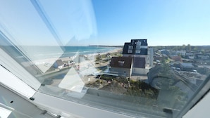 A coastal town with buildings, a beach, and a clear sky. - Strandschlösschen Appartement 15 - Strandschlößchen (Scharbeutz)