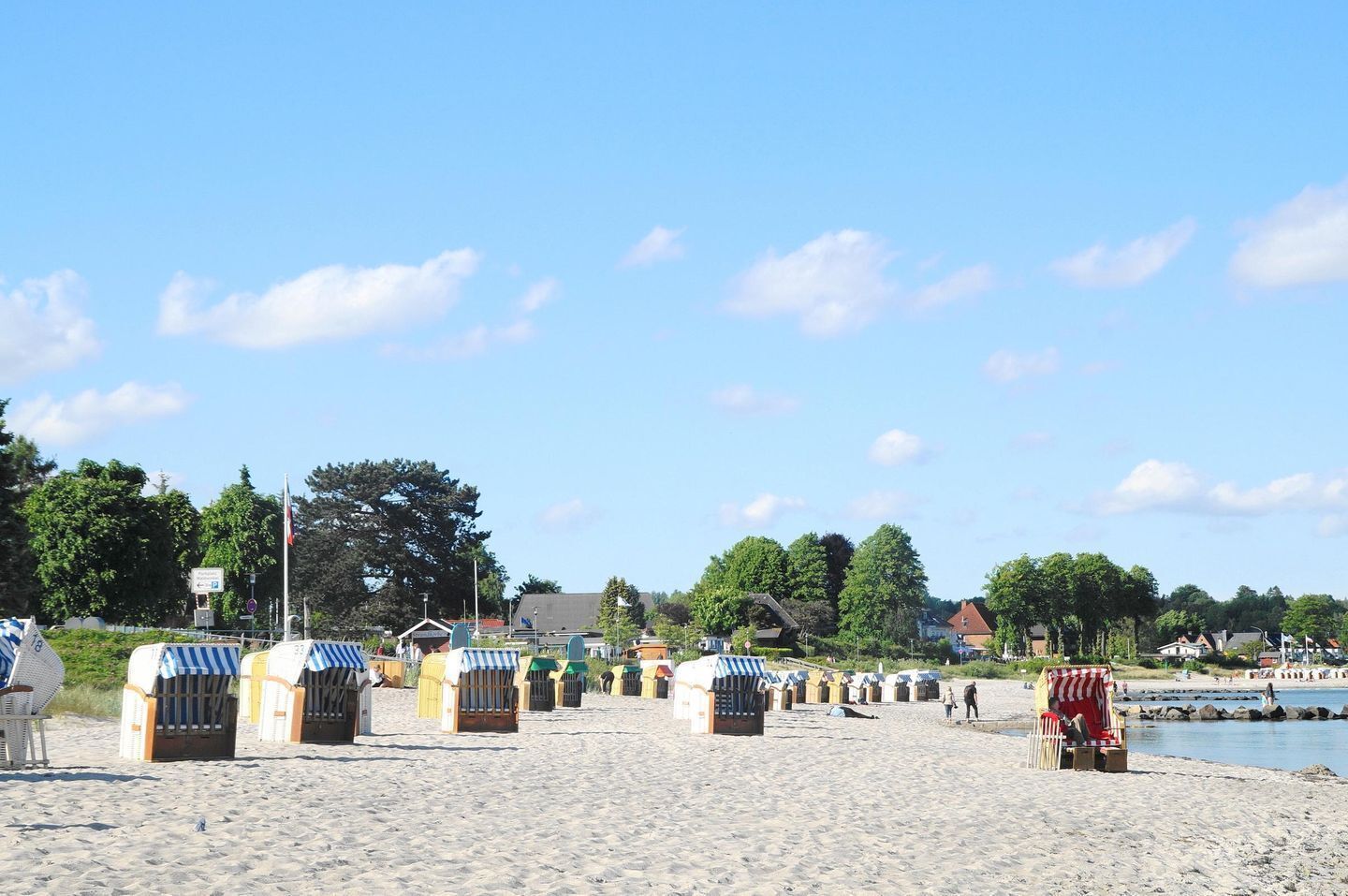 Una spiaggia con delle casette da spiaggia e uno specchio d'acqua sullo sfondo.