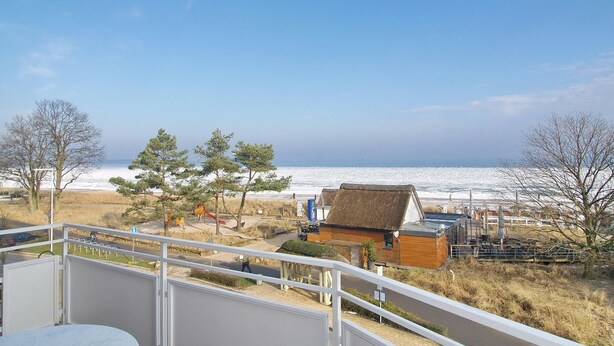 Ein Balkon mit Blick auf Strand und Meer.