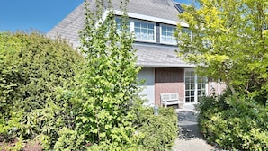 A two-story house with a brick facade, large windows, and a visible chimney. - Sandpiper Apartment 2 - Sandpiper (Scharbeutz)