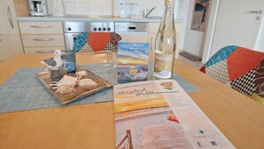Une table avec une bouteille de vin, un menu et un oiseau décoratif.