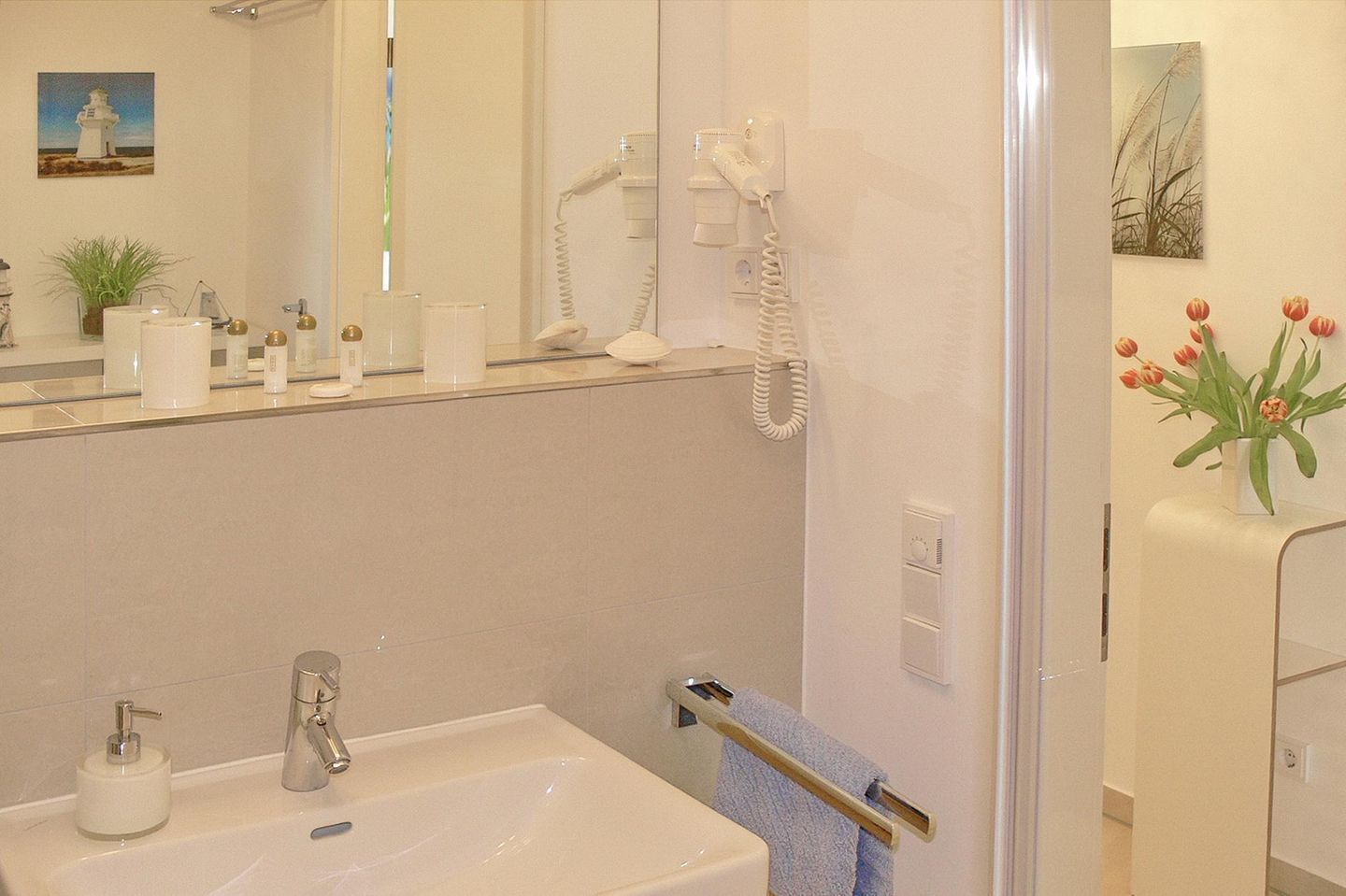 Ein modernes Badezimmer mit Waschbecken, Spiegel und Handtuchhalter.