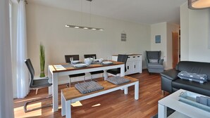 A modern living room with a dining area, a sofa, and a bench.