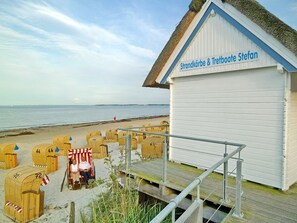 A beachside building with a sign reading "Strandkörbe & Tretboote Stefan". - Strandglück Apartment 22A - Strandglück Haus A (Scharbeutz)