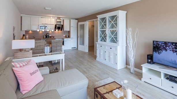 A modern living room with a sofa, a coffee table, a TV, and a cabinet. - Strandglück Apartment 8A StrandGutFinder.de - Strandglück Haus A (Scharbeutz)