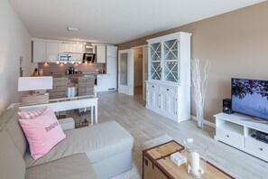 Een moderne woonkamer met een bank, een salontafel, een televisie en een kast.