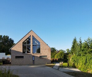 A modern building with a triangular roof and large windows. - Haus Küstenkinder Marie Apartment 1 - Haus Küstenkinder (Scharbeutz)