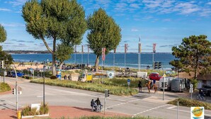 A coastal road with a beach in the background, a pedestrian path, and a few vehicles. - Seetempel Apartment 42 - Seetempel (Scharbeutz)