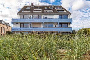 Un bâtiment à deux étages, doté d’un toit plat, de nombreuses fenêtres et d’une porte bien visible.
