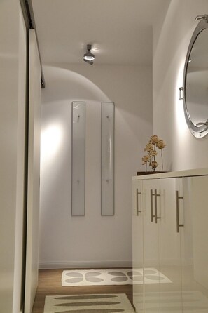 A modern bathroom with a glass shower enclosure, a white vanity with a mirror, and a decorative vase on the vanity. - Seetempel Apartment 45 - Seetempel (Scharbeutz)