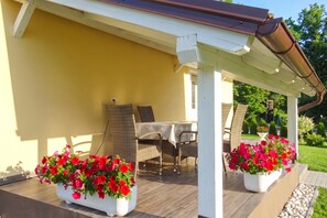 An outdoor patio with a table and chairs, surrounded by potted plants. - Villa Cujez with Pool & Sauna, Rečica ob Savinji, Slovenia (Rečica ob Savinji)