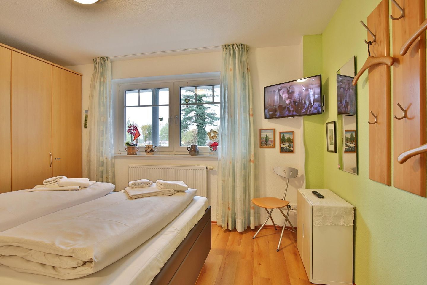 Une chambre à coucher avec un lit, une chaise, un téléviseur et un radiateur.