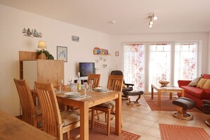 Un comedor con muebles de madera, un televisor y un sofá rojo.