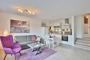 Un appartement moderne comprenant un salon, un coin repas et une cuisine.