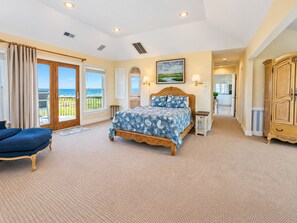Ein Schlafzimmer mit Bett, Stuhl, Kleiderschrank und Blick ins Freie.