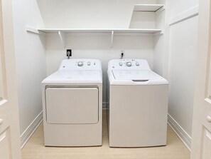 A laundry room with two front-loading washing machines and a shelf above them. - Goldenberg - 🏄Enjoy Spectacular Views from this 4 BR Oceanfront Home🏄 (Southern Shores)