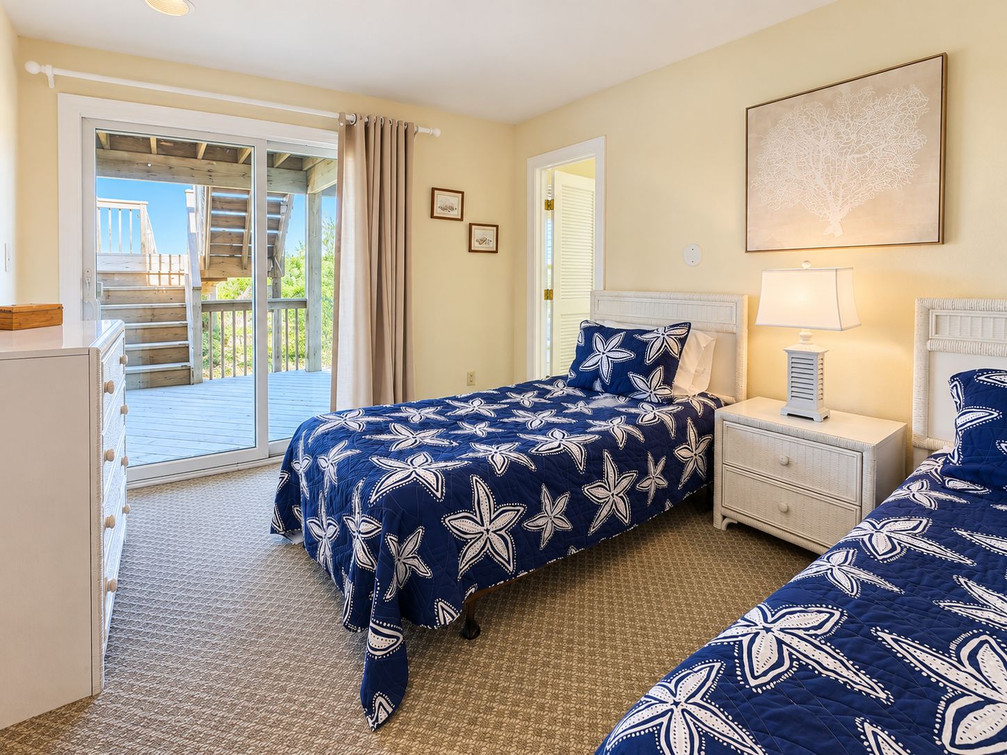 Une chambre à coucher avec un lit, des tables de chevet, une commode et un balcon.