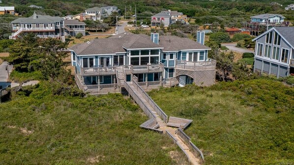 A coastal house with a large deck and multiple levels, surrounded by lush greenery. - Goldenberg - 🏄Enjoy Spectacular Views from this 4 BR Oceanfront Home🏄 (Southern Shores)
