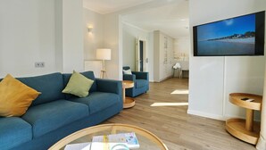 Un salon moderne avec un canapé, une table basse et un téléviseur fixé au mur.