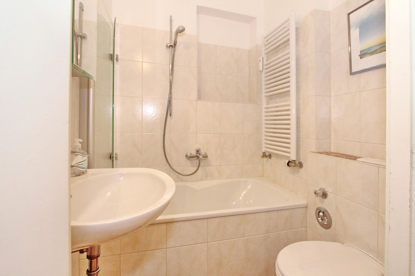 A bathroom with a sink, toilet, and shower.