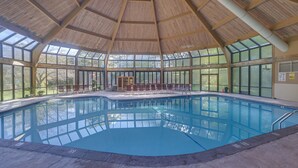 A large indoor swimming pool with a wooden ceiling and large windows. - Camelback Cabin 8  Poconos (Tannersville)