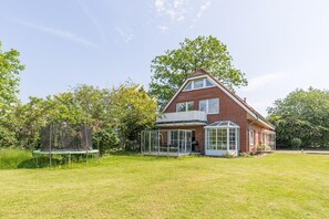 Punatiilisestä ulkoverhouksesta, parvekkeesta ja suuresta lasiterassista tunnettu kaksikerroksinen talo.