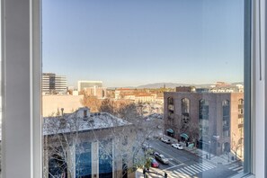 Overlooking the city, this room offers a view of various buildings, including a modern structure and a traditional brick building.